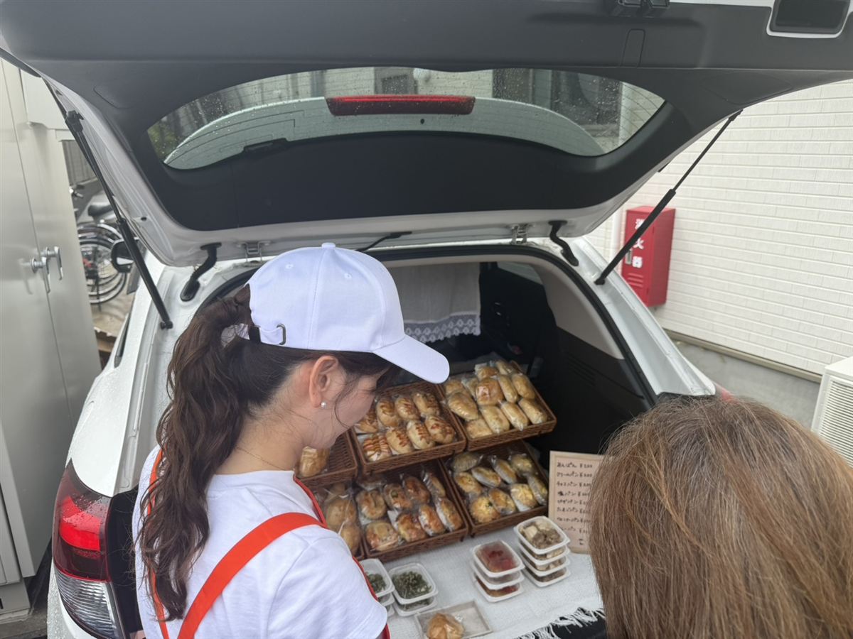 パンの移動販売で好きなパンを選ぶ入居者