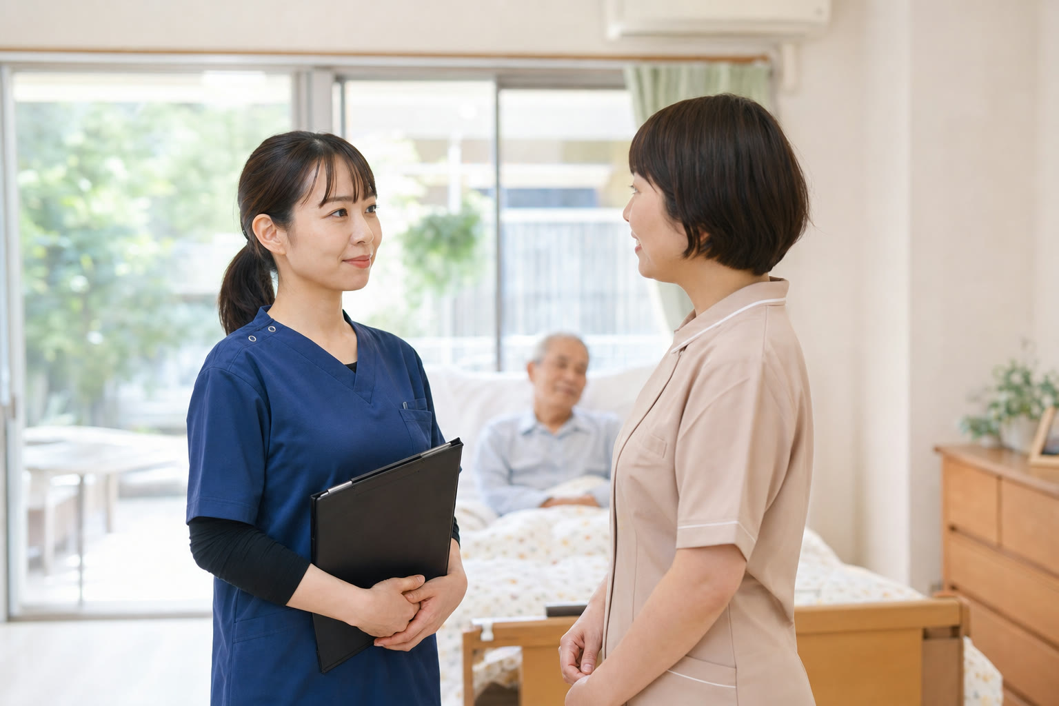 居室で施設職員と訪問看護師が情報を共有している様子